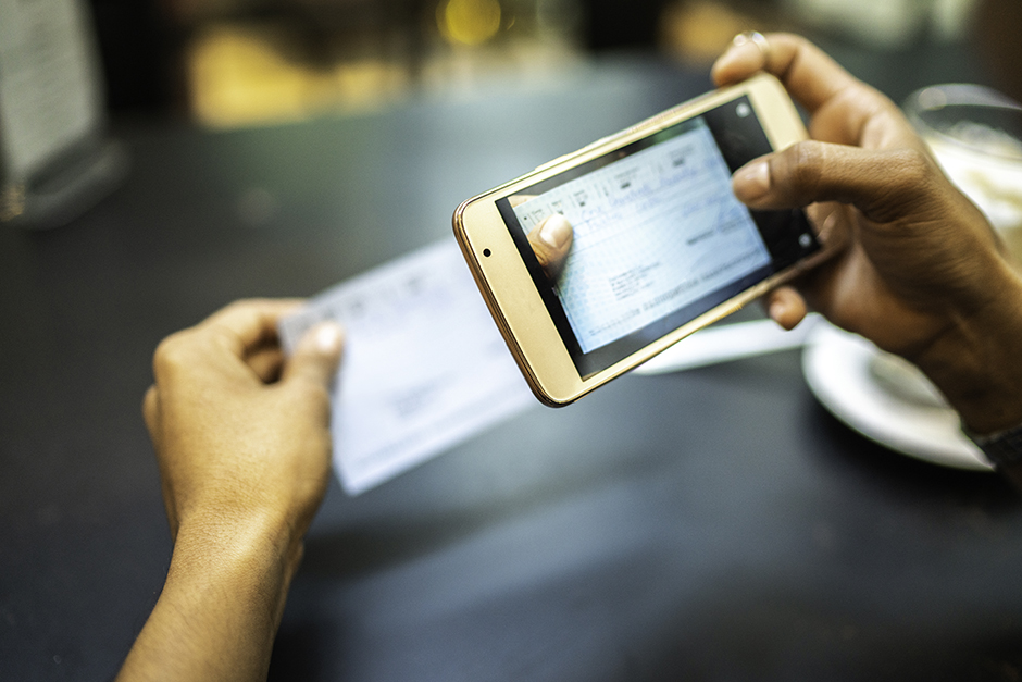Person depositing a check with a mobile phone